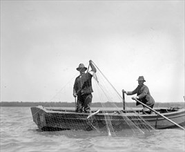 Two men with a net shad fishing on the Potomac River ca. between 1909 and 1932