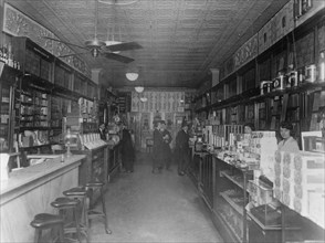 Interior of People's Drug Store, 11th and G Streets, Washington, D.C., with employees behind the counters and customers ca. between 1909 and 1932