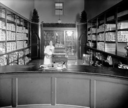 Worker behind the counter at the Palace Laundry ca.  between 1918 and 1928