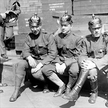 Soldiers wearing helmets used in Victory Loan, boxes from the U.S. Treasury Department in the background ca.  between 1918 and 1920