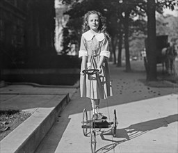 Girl riding on a tricycle like toy ca.  between 1918 and 1920