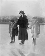 Mother and children ice skating outside ca.  between 1918 and 1920