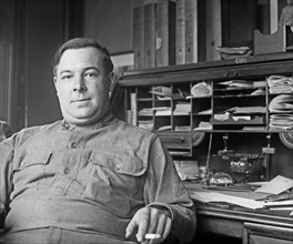 Frank Stowell sitting at his desk ca.  between 1918 and 1920