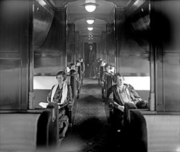 African American train attendent and passengers aboard a Southern Railway train car, interior of car ca.  between 1918 and 1928