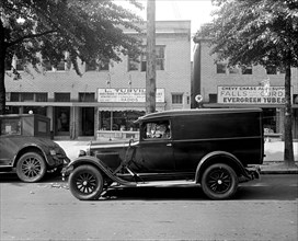 Man driving a delivery truck outside Turville Hardware store, possibly in Chevy Chase Maryland ca.  between 1918 and 1928