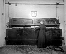 Woman baking, using a commercial oven at the Caking Baking Company group ca.  between 1918 and 1928