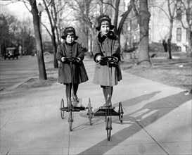 Children of Roger Nielson, Danish Legation; Rita & Ruth, playing on stand up tricycles ca.  between 1918 and 1920