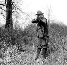 E.T. Meredith Jr. pointing a shot gun or rifle toward the camera  ca.  1920