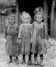Three children, dirty from their work as oyster shuckers in Port Royal, SC ca. between 1909 and 1919