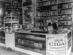 Interior of People's Drug Store, 7th and M Streets, Washington, D.C., with employee behind counter with display of candy and cigars ca. between 1909 and 1932