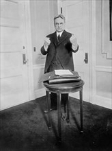 Senator Hiram Johnson holding out his fists as to make punching motion ca. 1909
