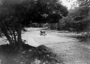 Car crossing a flooded stream in a park, possibly Rock Creek Park, in Washington, D.C. ca. [between 1909 and 1932]