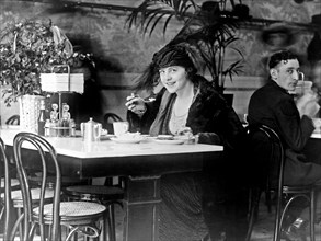 Woman eating in a restaurant ca. 1909