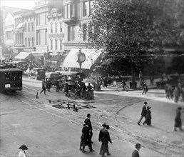Street scene showing people, a streetcar, automobiles and buildings at the corner of a Washington, D.C. street. ca. [between 1909 and 1920]