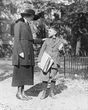 A policewoman in training, speaking to a young man, possibly a newsboy ca. 1909