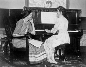 Young ladies sitting at a piano  ca. 1909