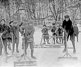 Boys cleaning snow off the ice, so that they can ice skate, Washington, D.C., area ca. 1909