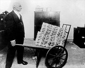 Treasury. A $75,000 wheelbarrow of mutilated money on way to vaults. Employee in picture has wheeled barrow 50 years ca. 1909