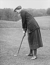 Miss Elsie Patterson, full-length portrait, standing, facing left, ready to hit golf ball ca. 1909