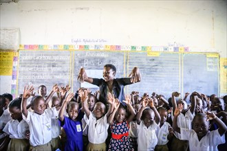 Young school students in Uganda have fun in the classroom with their teacher ca. 23 February 2017