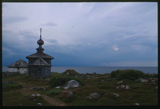Church of St. Andrew (1702), east view, with stone dwelling (mid 16th century), and White Sea in background, Bol'shoi Zaiatskii Island, Russia; 1999