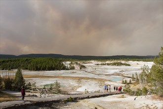 Visitors in Porcelain Basin at Norris Geyser Basin in Yellowstone National Park. Smoke filled sky from the Maple Fire; Date: 22 August 2016