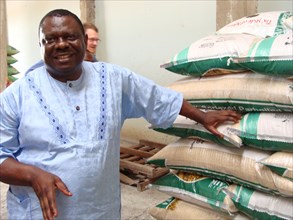 Nigerian farmer and bags of processed rice ca. 17 May 2014
