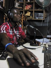 A radio show host in the studio in Liberia ca. 11 September 2013