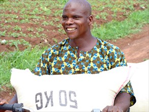 Nigeria Farmer, possibly holding a 50 kg bag of grain -   ca. 18 May 2014