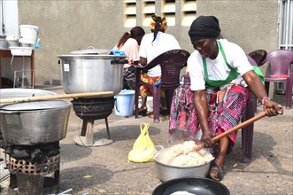 A woman cooking and mixing rice to be used for donuts made from rice in outskirts of Kinshasa ca. 2 June 2017