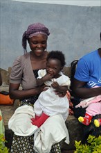 Diana, 25, holds her 7 month old daughter, Patience, during a women's breastfeeding group meeting at the Rukiga District IV Hospital (Uganda) ca. 13 March 2018
