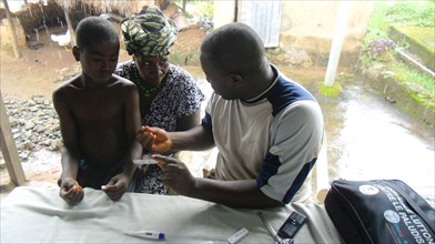 A child goes for malaria testing and treatment in a rural area in Guinea ca. 13 September 2012