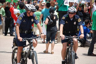 Iranians in Texas taking part in a Freedom for Iran rally at Dallas City Hall plaza in downtown Dallas, TX; two police officers on bicycles ca. June 2009