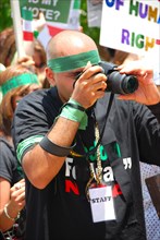 Photographer takes photos of Iranians in Texas taking part in a Freedom for Iran / Green Revolution rally at Dallas City Hall plaza in downtown Dallas, TX ca. June 2009