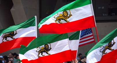 Iranians in Texas taking part in a Freedom for Iran / Green Revolution rally at Dallas City Hall plaza in downtown Dallas, TX; Iranian flags waving in the wind ca. June 2009