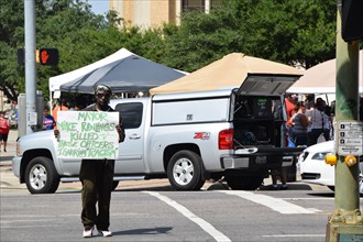 Dallas, Texas, USA. 10th July, 2016 An African American man holds a counter protest sign at a gathering of citizens in front of Dallas police headqurters who have come to show support for the police