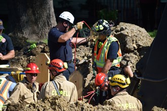 First responders; firemen and paramedics, help trapped construction worker trapped in a trench; Irving, TX USA