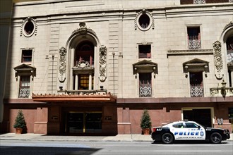 A police car parked in front of the Adolphus Hotel building in downtown Dallas, TX