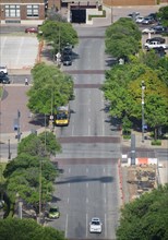 Aerial view of a street in downtown Dallas, TX; a yellow DART bus in the center of the frame