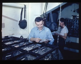 John R. Ryan sorting mail in the USS RANDOLPH post office