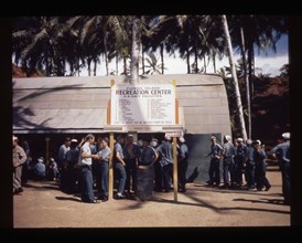 Sailors gathered around the center's sign, 1944