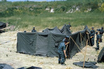 Marines erect a tent at a temporay housing facility for Vietnamese refugees.