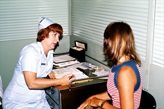 A nurse screens a woman prior to her admittance as a patient at the Hospital.