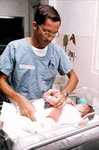 Worker changing the diaper of a newborn baby