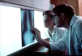 A doctor and nurse examine an X-ray.