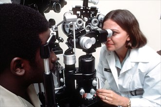A female U.S. Army optometrist conducts an eye exam.