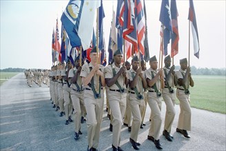 A color guard of US Army recruits marches in formation.