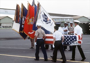 A combined services Color Guard stands by as  pallbearers carry the flag