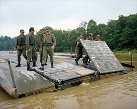 A ribbon bridge is assembled by members of the 1457th Engineering Battalion