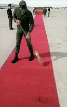 Airmen place a red carpet on the ground